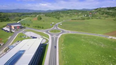 Güzel bir döner kavşak doğanın ortasındadır. Bir çift araba ona çarpıyor..