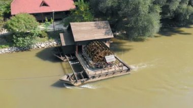 Güneşli bir günde nehirdeki eski su değirmeninin hava görüntüleri.