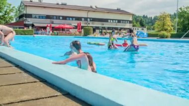 DOMZALE, SLOVENIA - 20. HAZİRAN 2015 Şimdilik yüzmeyi bitirdiler ve sudan çıkıyorlar. Güzel ve güneşli bir gün..