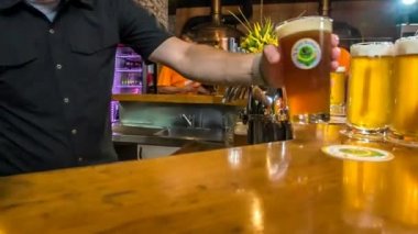 DOMZALE, SLOVENIA - 16. Temmuz 2018 Bier minderde koyu bier var. Barmen bu geceki basketbol maçında bir sürü bira dolduruyor..
