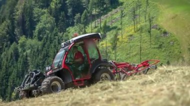 Genç bir çiftçi dağlardaki büyük bir çim tarlasında saman ayıklıyor. Yaz ayındayız ve gün çok sıcak..