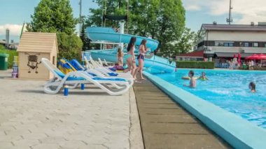DOMZALE, SLOVENIA - 20. HAZİRAN 2015 Kızlar yüzme havuzunun kenarında duran arkadaşlarına su sıçratıyor..