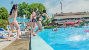 DOMZALE, SLOVENIA - 20. Haziran 2015 gençleri birer birer yüzme havuzuna atlıyorlar ve çok eğleniyorlar. Çok güzel güneşli bir gün..