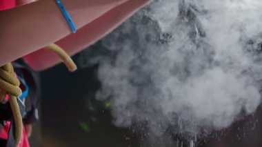 Elinde tebeşirle tırmanıyor ve tebeşir düştüğünde toz oluyor. Çocuklar tırmanma duvarına tırmanıyor..