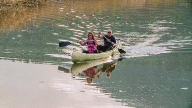 Bu çift yavaşça nehirde kürek çekiyor ve bu günün tadını birlikte çıkarıyorlar. Sakin bir gün..