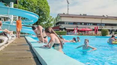 DOMZALE, SLOVENIA - 20. HAZİRAN 2015 Yüzme havuzundan çıkan iki kız. Sıcak bir yaz günü..