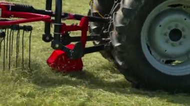Bir traktör sahada çok hızlı gidiyor ve döner tırmıklar çok hızlı çalışıyor..