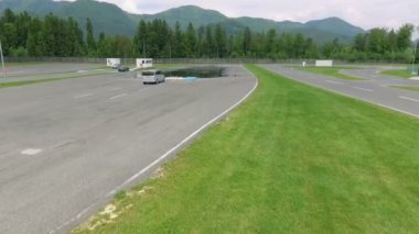 Gri bir minibüs kaygan bir yolda giderken yönünü değiştiriyor ve hareket etmeye başlıyor. Bu güvenli bir sürüş merkezinde gerçekleşiyor..