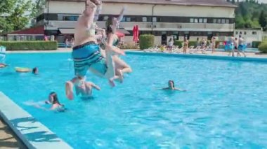 DOMZALE, SLOVENIA - 20. HAZİRAN 2015 Üç öğrenci aynı anda suya atlıyor. Yaz mevsimindeyiz ve güneş parlıyor. İyi vakit geçiriyorlar..