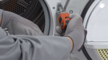 Servis merkezindeki çamaşır makinesinin yakın çekim görüntüleri.