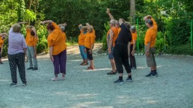 DOMZALE, SLOVENIA - 21. HAZİRAN 2015 Yaşlılar kollarını havaya kaldırıyorlar ve vücutlarının bir tarafını geriyorlar..