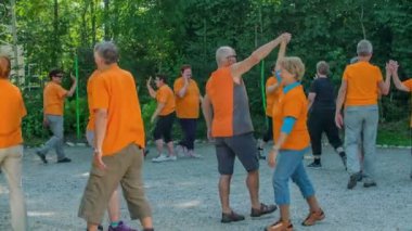 DOMZALE, SLOVENIA - 21. Haziran 2015. Bu güzel yaz gününde bir grup insan birlikte spor yapıyor. İki daire çizip birbirlerine beşlik çakıyorlar..
