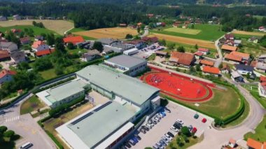 GRIZE, SLOVENIA - 10. Haziran 2017 Okul ve spor merkezinin yükseltilmiş yardım haritası. Okul güzel küçük bir köyde yer almaktadır. Çocuklar dışarıda oynuyorlar. Hava görüntüsü.