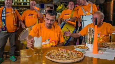 DOMZALE, SLOVENIA - 16. Temmuz 2018 'de sarhoş destekçilerden biri bardaki masaya bir sürahi fırlattı. Diğer destekçiler onu sakinleştirmeye çalışıyor. Üzgün görünüyor..