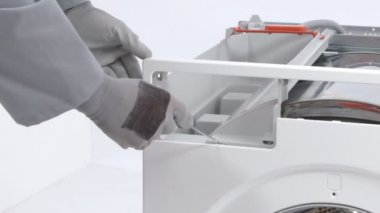 Servis merkezindeki çamaşır makinesinin yakın çekim görüntüleri.