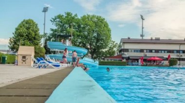 DOMZALE, SLOVENIA - 20. Haziran 2015 'te genç yetişkinler havuz kenarında takılıyorlar. Sıcak bir yaz günü..