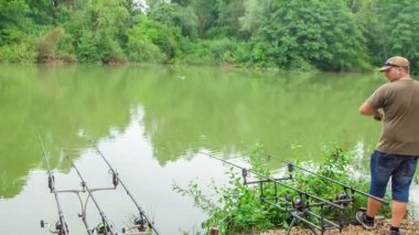 Bir balıkçı balık tutarken başarılıdır ve şimdi oltayı sallıyor çünkü oltaya takılmış bir balık yakaladı..