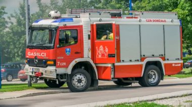 DOMZALE, SLOVENIA - 7. Temmuz 2018 İtfaiyecileri itfaiye arabasından fırlıyor. Yakınlarda bir yerde yangını söndürmeleri gerekiyor..