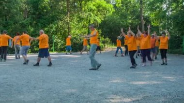 DOMZALE, SLOVENIA - 21. Haziran 2015 'te bir grup son sınıf öğrencisi parkta spor yapıyor. Daire çiziyorlar. Ellerini havaya kaldırıyorlar ve sonra tekrar indiriyorlar..