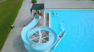 DOMZALE, SLOVENIA - 20. Haziran 2015 'te çocuklar eğleniyorlar ve bazıları su kaydırağına atlayıp havuza düşüyorlar..