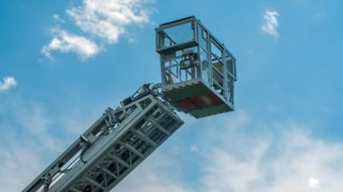 İtfaiye aracındaki bir asansör yukarı çıkıyor ve bir binanın tepesinde yaralanan yaralı bir kişiyi kurtaracak..