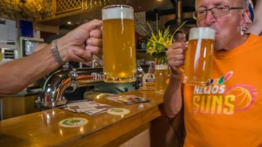 DOMZALE, SLOVENIA - 16. HAZİRAN 2018 İki destekçi büyük bier sürahi ile kadeh kaldırıyor. Bu gece barda çok fazla içki içiliyor..