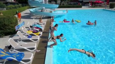 DOMZALE, SLOVENIA - 20. Haziran 2015 Bütün gençler birbiri ardına yüzme havuzuna atlıyor. Hava görüntüsü. Sıcak bir yaz günü..