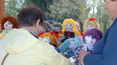 DOMZALE, SLOVENIA - 17. Haziran 2018 'de yaşlı bir kadın bebekler arasında seçim yapıyor. Hediye olarak bir iki tane almak istiyor..