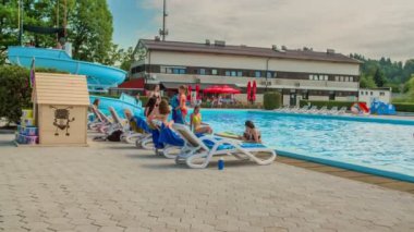 DOMZALE, SLOVENIA - 20. Haziran 2015 Havuz kenarında dinlenme zamanı. Çocuklar yüzüyor ve birlikte vakit geçiriyorlar. Yaz zamanı..