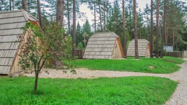 Küçük ahşap evler bir ormanın ortasında yer alır. Doğa güzel ve yeşil.