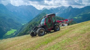 Bir traktör katlanıyor ve bir çiftçi dik tepeden ayrılıyor. Saman hazırlamayı bitirdi..