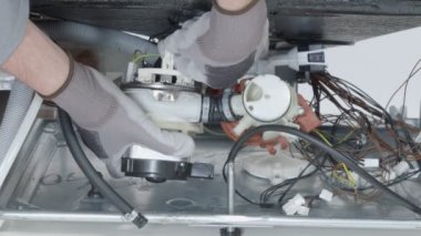 Servis merkezindeki çamaşır makinesinin yakın çekim görüntüleri.