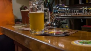 DOMZALE, SLOVENIA - 16. Temmuz 2018 Bir barda tezgahın üzerinde bir sürü bira var. Hayranlar içiyor ve iyi vakit geçiriyorlar..