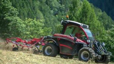 Genç bir çiftçi dağlarda saman hazırlıyor. Yaz mevsimindeyiz. Arkadaki tepeler çok güzel görünüyor..