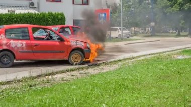 DOMZALE, SLOVENIA - 7. 2018 Temmuz 'unda bir araç yanıyor ve itfaiyecilerin gelip itfaiyeyle mücadele etmeleri gerekiyor..