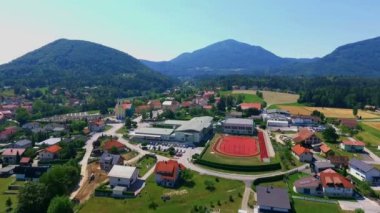 GRIZE, SLOVENIA - 10. Haziran 2017 Tepeleri küçük bir köyü çevrelemektedir. Okulun yanında büyük bir kırmızı spor tesisi var..