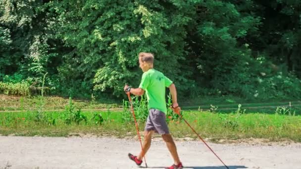 Beeldmateriaal Van Volwassen Man Joggen Met Trekking Palen Natuur — Stockvideo