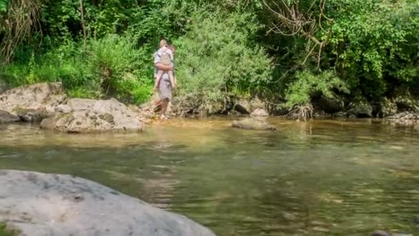 Mężczyzna Trzyma Dziecko Próbuje Przejść Przez Rzekę — Wideo stockowe
