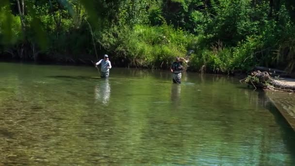 一个人把他的钓竿扔得很远 两个渔夫正在这条河里钓鱼 度过他们的一天 — 图库视频影像