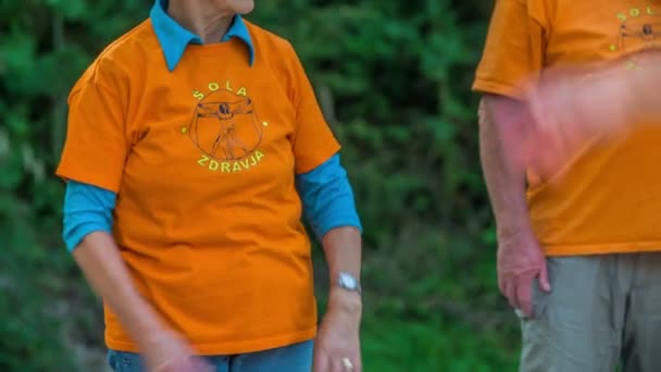 Domzale Slovenia 2015年6月2本の腕を持つ高齢者が同時に旋回している 彼らはオレンジのTシャツを着ている — ストック動画