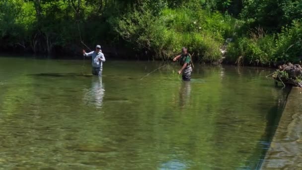 Двое Мужчин Стоят Воде Бросают Удочки Поймать Рыбу — стоковое видео