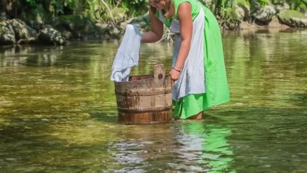 Młoda Dziewczyna Pięknej Sukience Pilnie Pracuje Myje Ubrania Drewnianym Wiadrze — Wideo stockowe