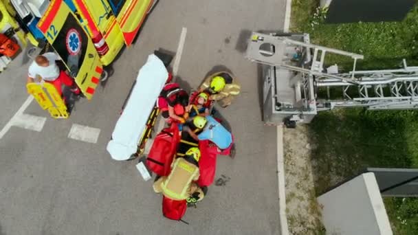Kurtarma Ekipleri Yaralı Birini Ambulansa Bindirmeye Çalışıyor Bir Binanın Tepesine — Stok video