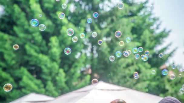 Mýdlové bubliny se vznášejí na obloze a umělec dělá obří bublinu