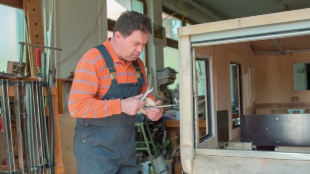중년의 나무꾼이 집에서 자신의 작업장에서 설계하고 빈티지 거울을 조정하기 종류의 — 비디오
