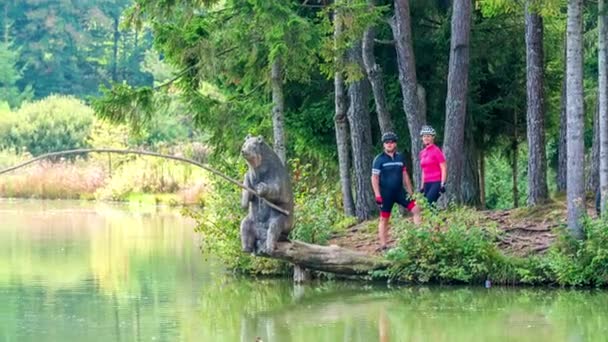 Dwóch Rowerzystów Stoi Brzegu Jeziora Obserwuje Jezioro Wskazują Coś Oddali — Wideo stockowe