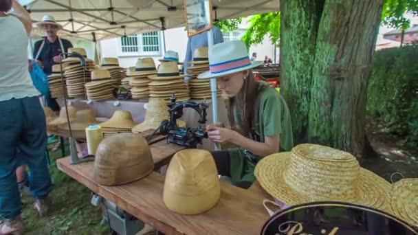一个正在帮助父母销售草帽的小女孩也在帮助做草帽 节期间是个不错的夏日 — 图库视频影像