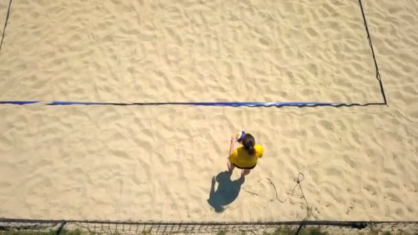 一位年轻女子正在排球比赛中发球 四个人在一个漂亮的沙地排球场上玩这个游戏 空中射击 — 图库视频影像