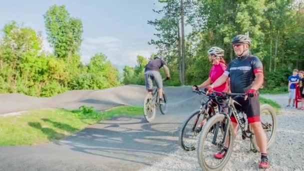 Zwei Ältere Leute Auf Fahrrädern Beobachten Andere Junge Leute Beim — Stockvideo