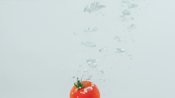 Tomate Con Pedicelo Cae Agua — Vídeos de Stock